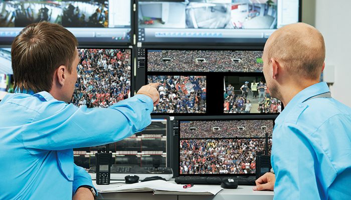 security executive chief discussing activity with worker in front of video monitoring surveillance security system